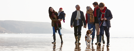 Image of a family walking along the beach in the fall time